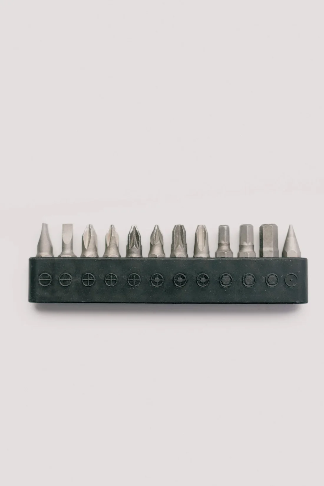 Silver screwdriver bits organized in a holder against a clean white background