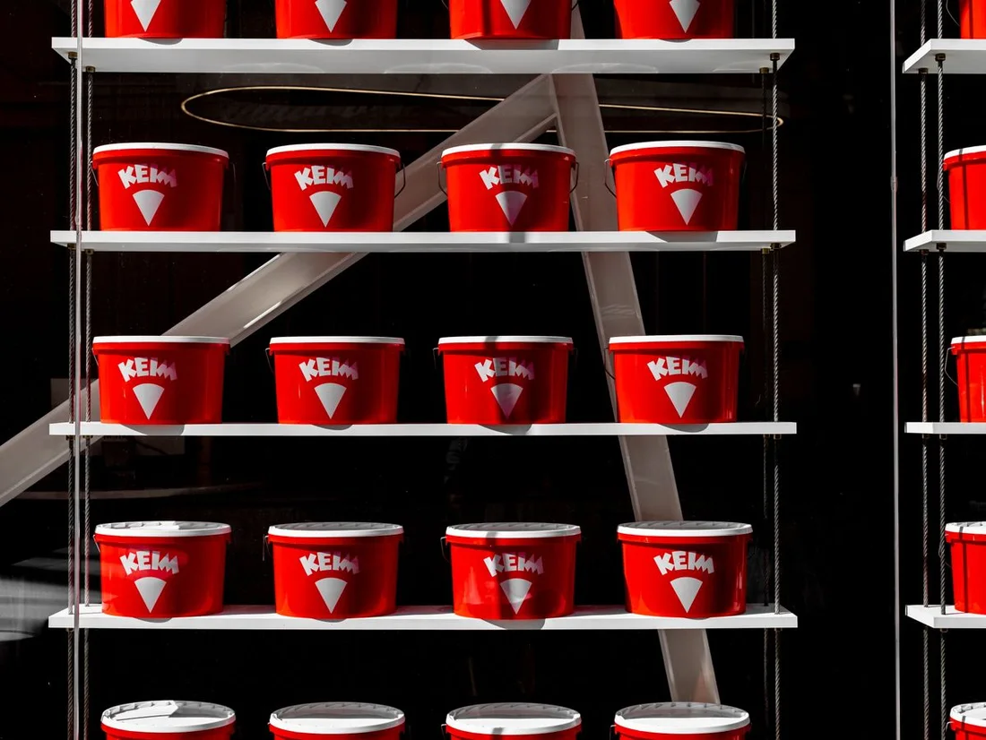 New sealed red paint containers neatly arranged on display shelves