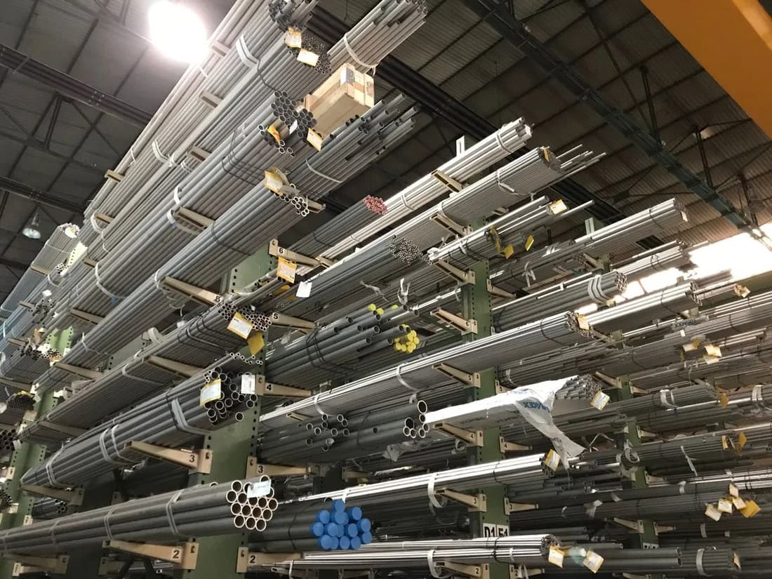 Metal tubes organized in bulk-storage racks inside an industrial warehouse