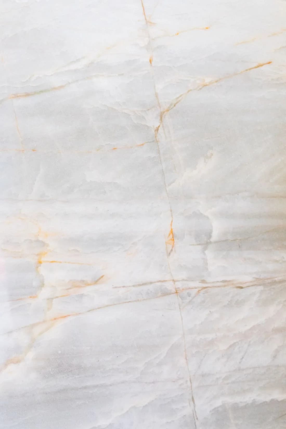 Pale polished stone surface with fine gold and gray natural veining