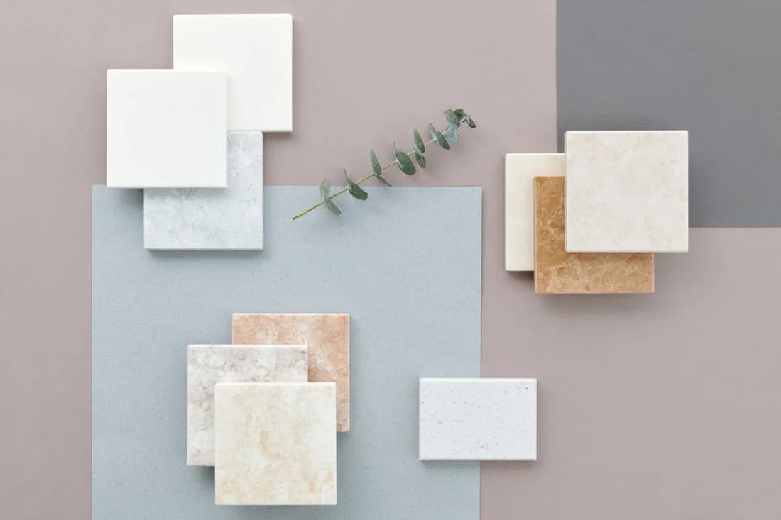 Real tile and stone surface samples arranged on a gray background