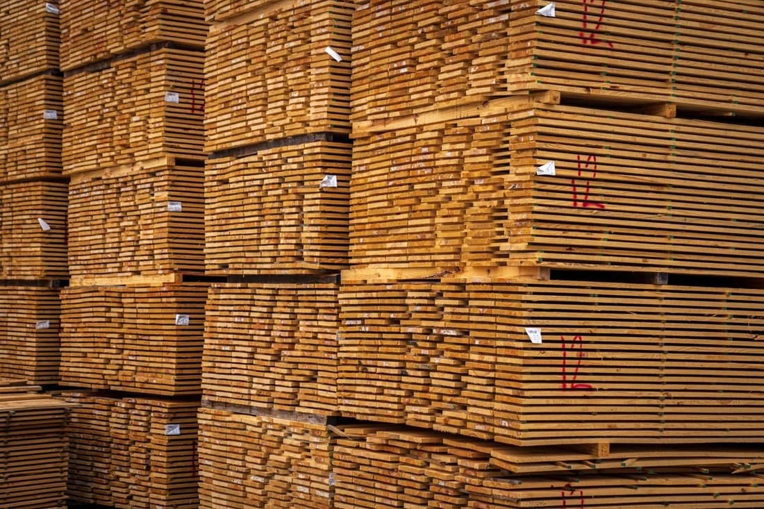 Uniform sawn timber boards neatly stacked in an indoor storage setting