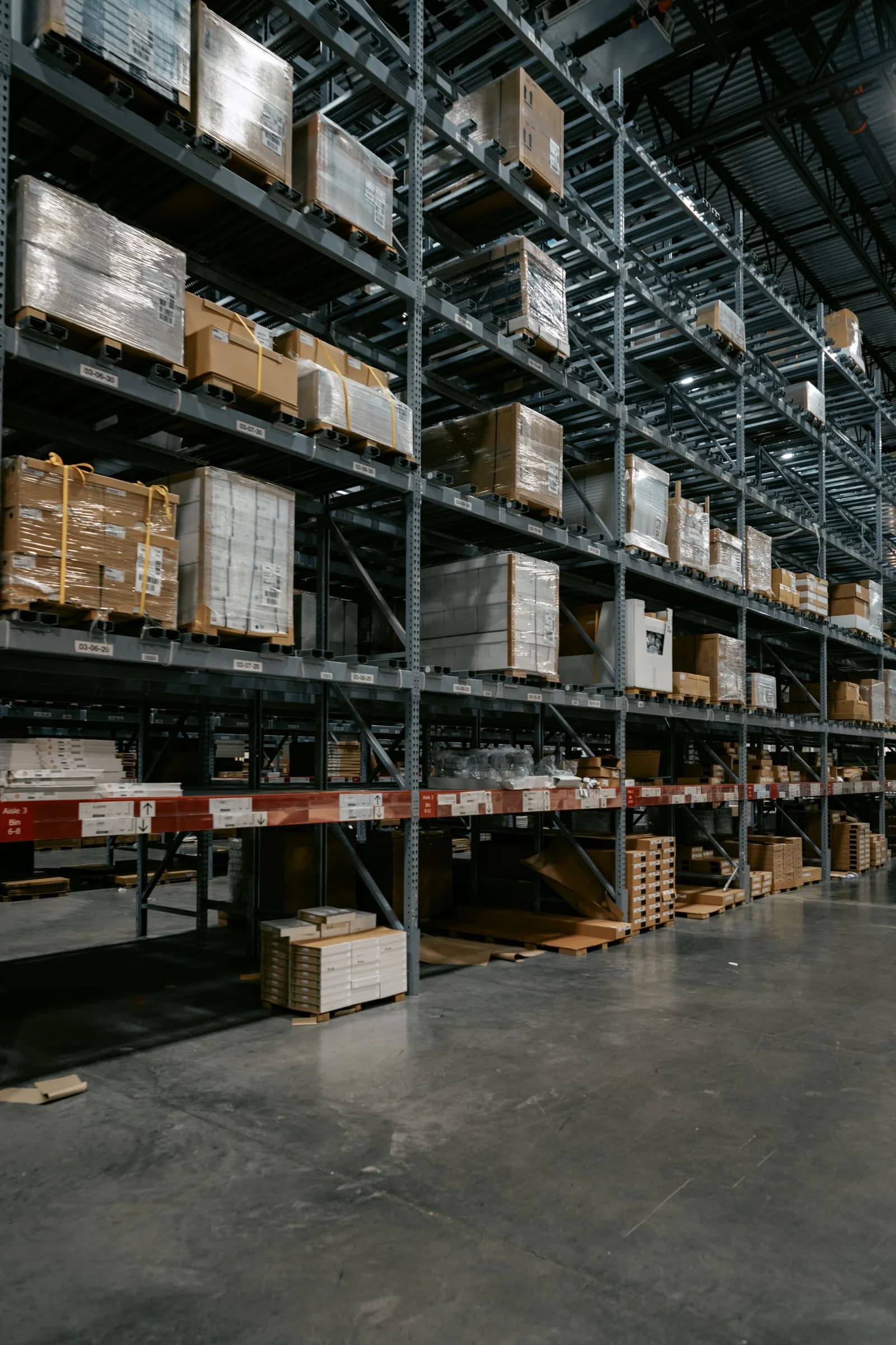 Stock photograph of wrapped material bundles arranged on clean industrial warehouse racks